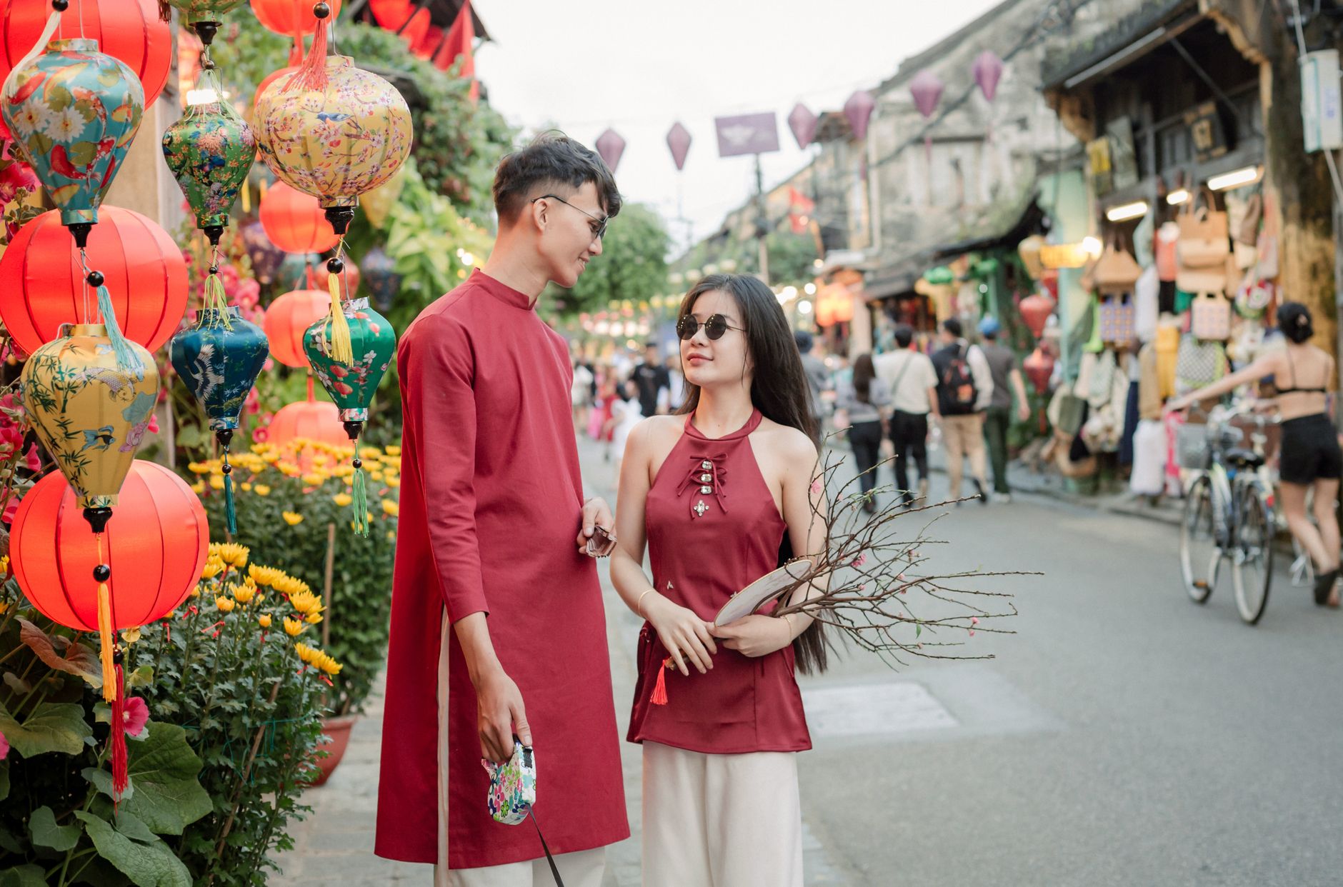 A couple enjoys the vibrant Lantern Festival in Hội An, Vietnam, wearing traditional attire.