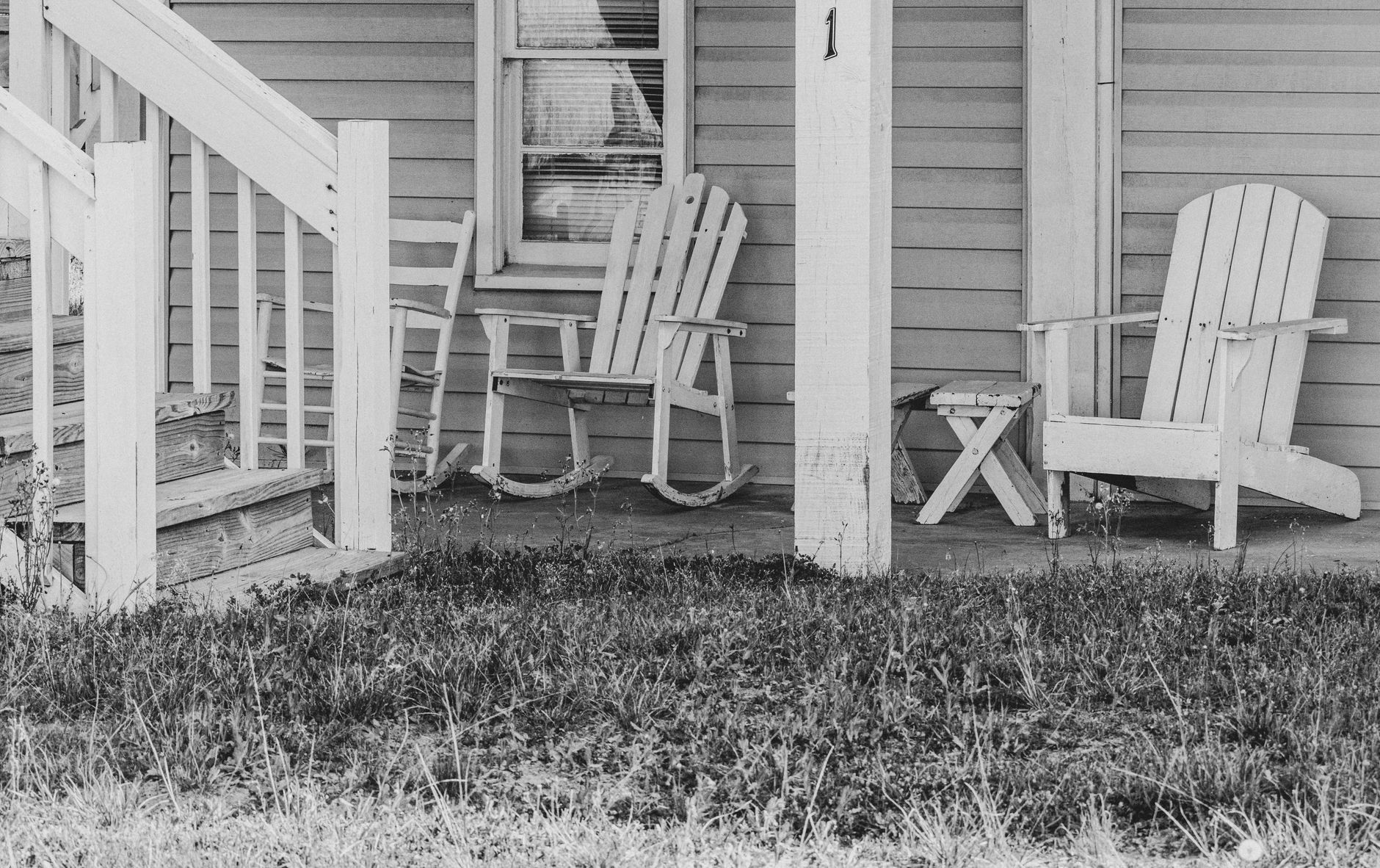 Two chairs on a porch with tea cups