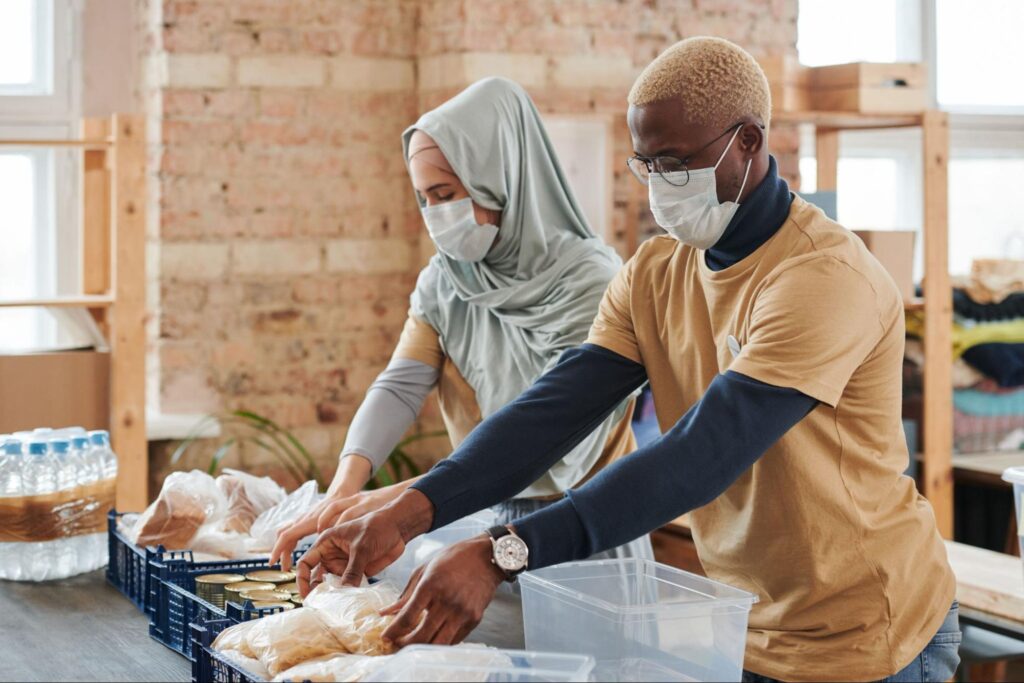 Couple volunteering together packing food donations at a community pantry
