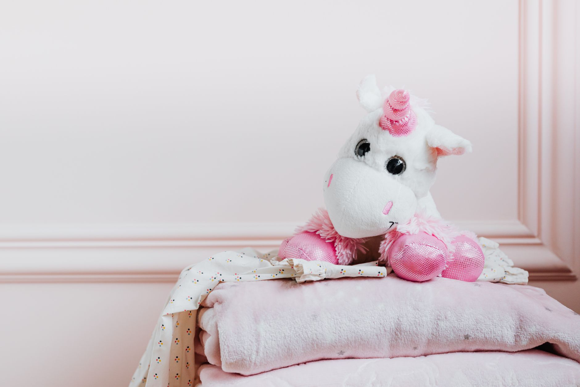 A cozy blanket and stuffed animal on a bed