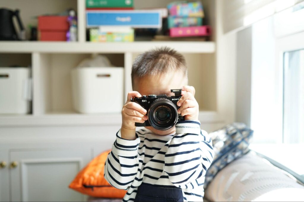 Young child holding a camera up to take a photo