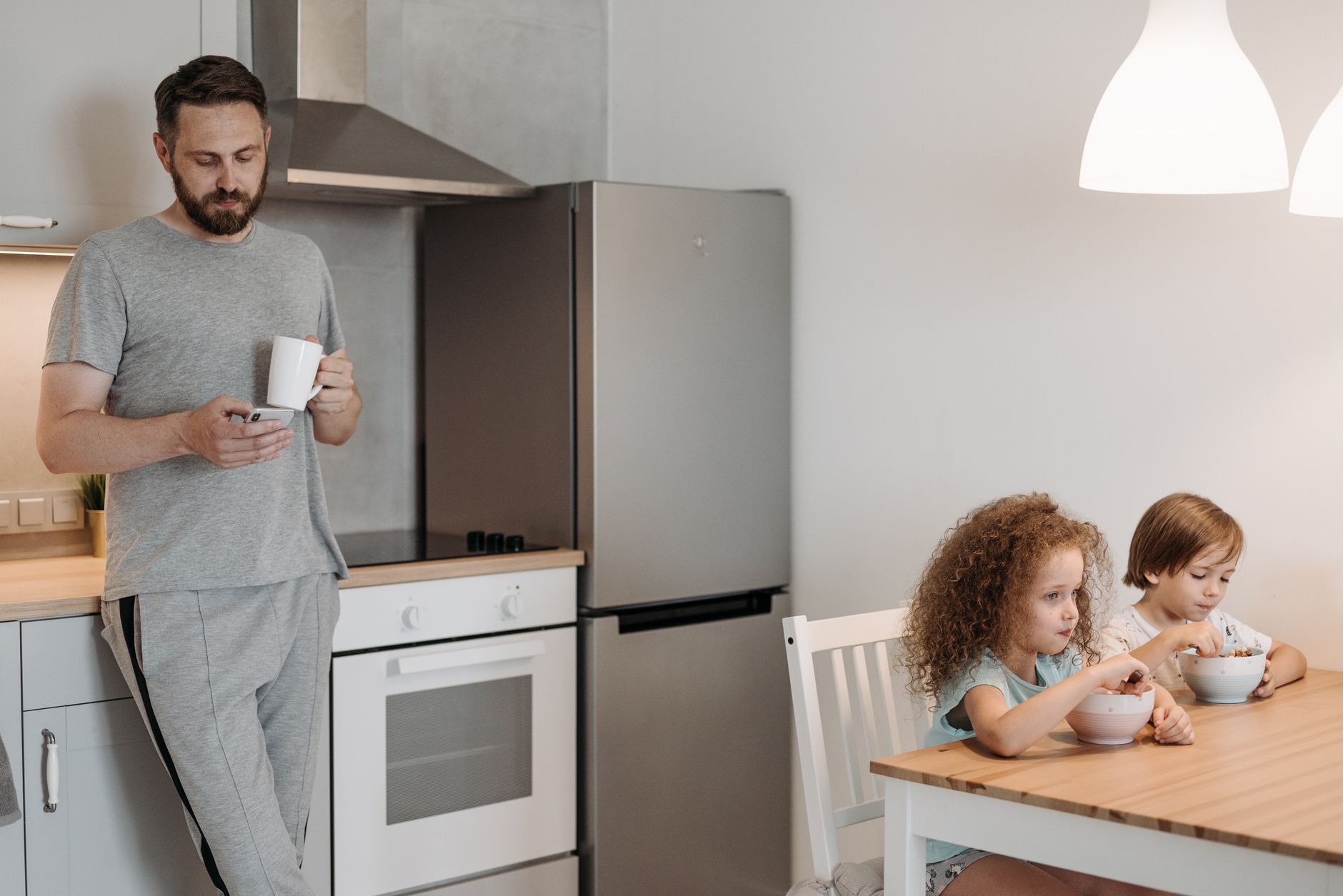 Man and children having breakfast in a cozy kitchen setting.