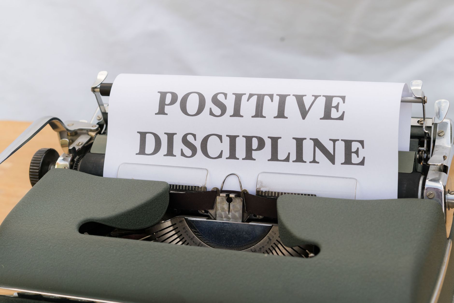 Image of the words 'Positive Discipline' typed on a vintage typewriter, symbolizing constructive communication.