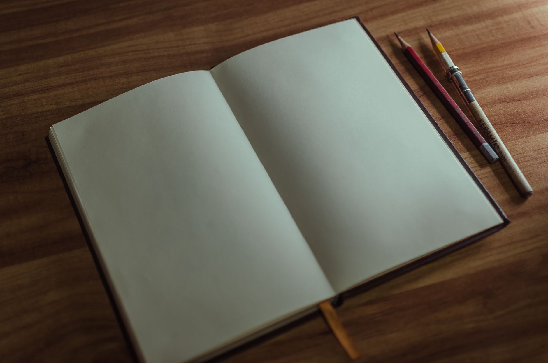 An open storybook and pencils on a desk
