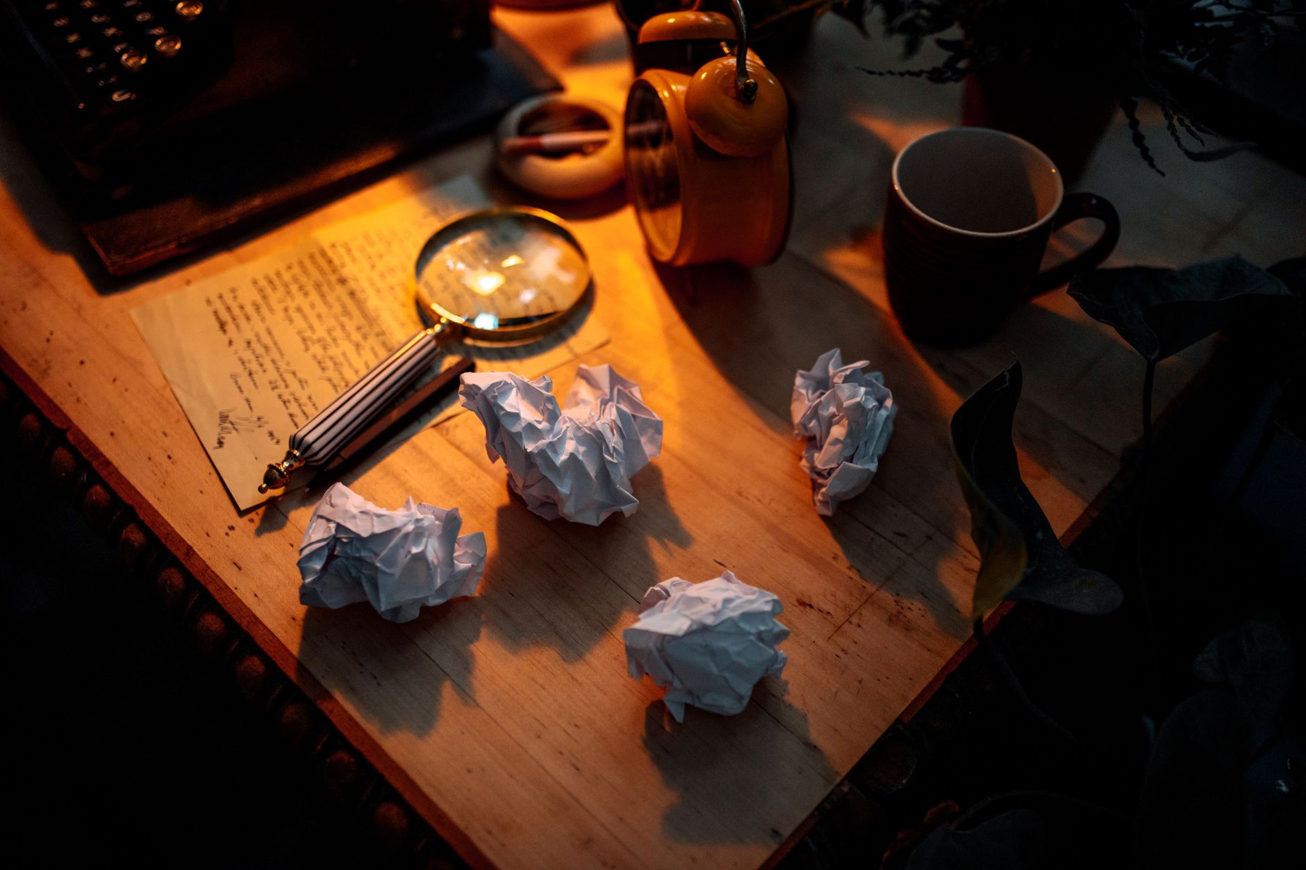 A paper airplane on a desk by a window